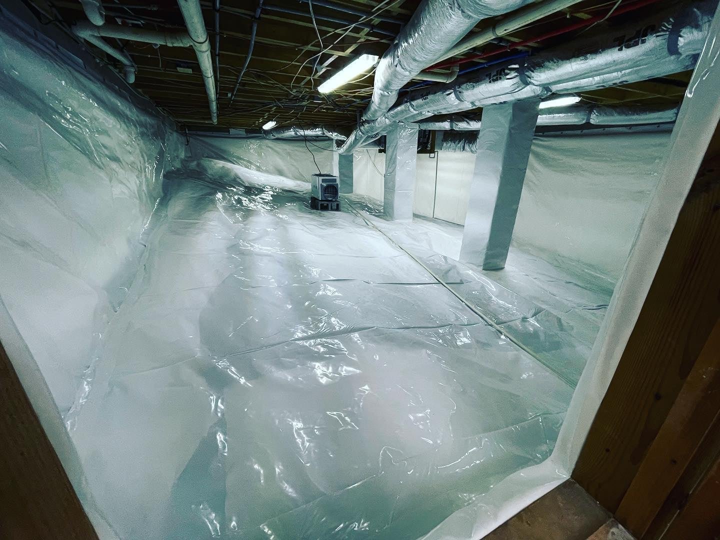 Technician inspecting basement wall cracks: Crawlspaces and Waterproofing of Cumming